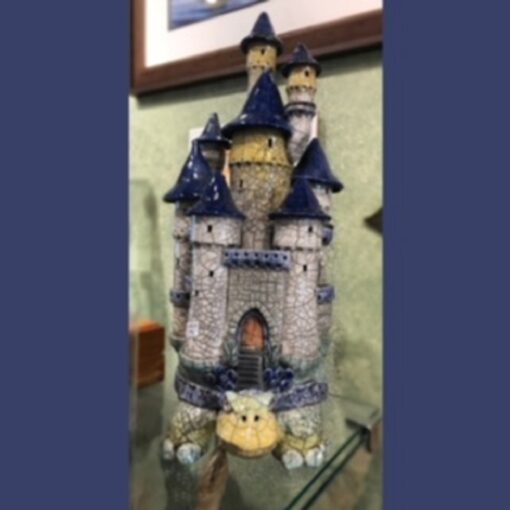 A ceramic castle with a cat inside of it.