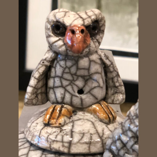 A ceramic owl sitting on top of a table.