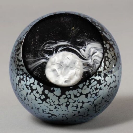 A black and white ball with a silver swirl on it.