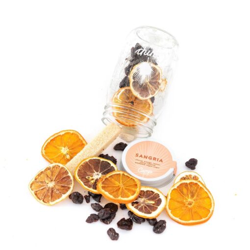 A jar of orange slices and raisins on top of the table.