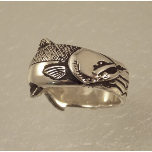 A silver ring with an animal on it's side.